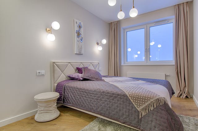 a bedroom with a violet throw